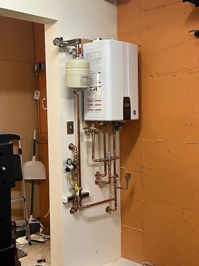 Plumbing technician inspecting water heater connections in Indian Trail
